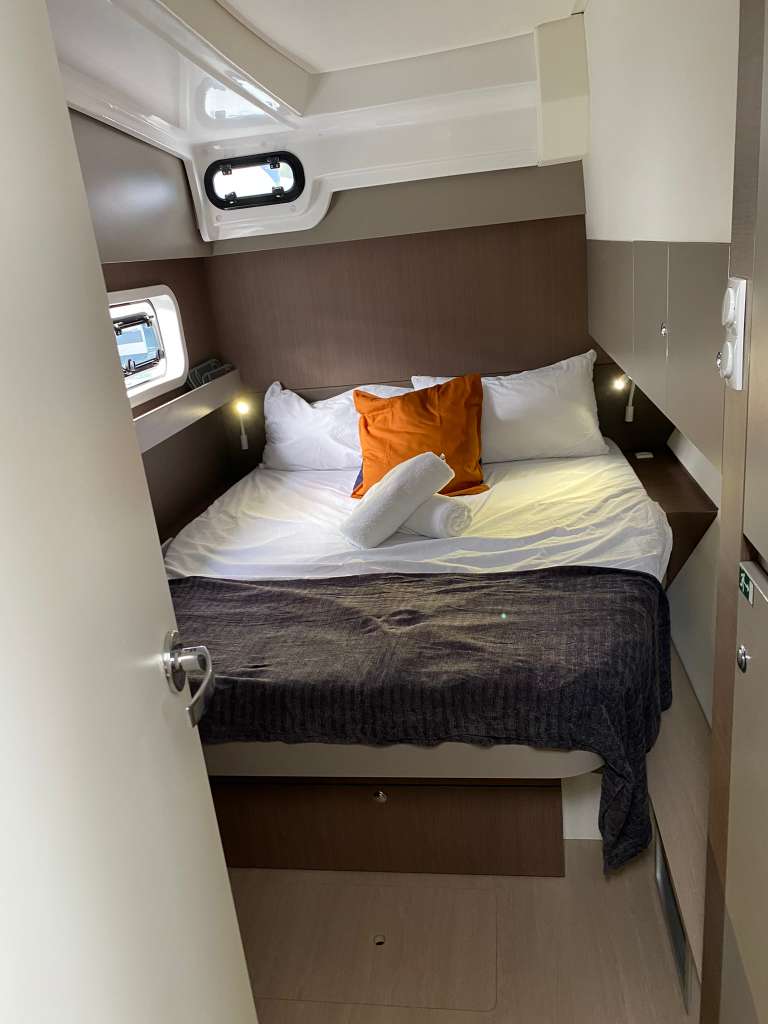 Bali Catspace guest cabin with queen bed, porthole, and reading lights