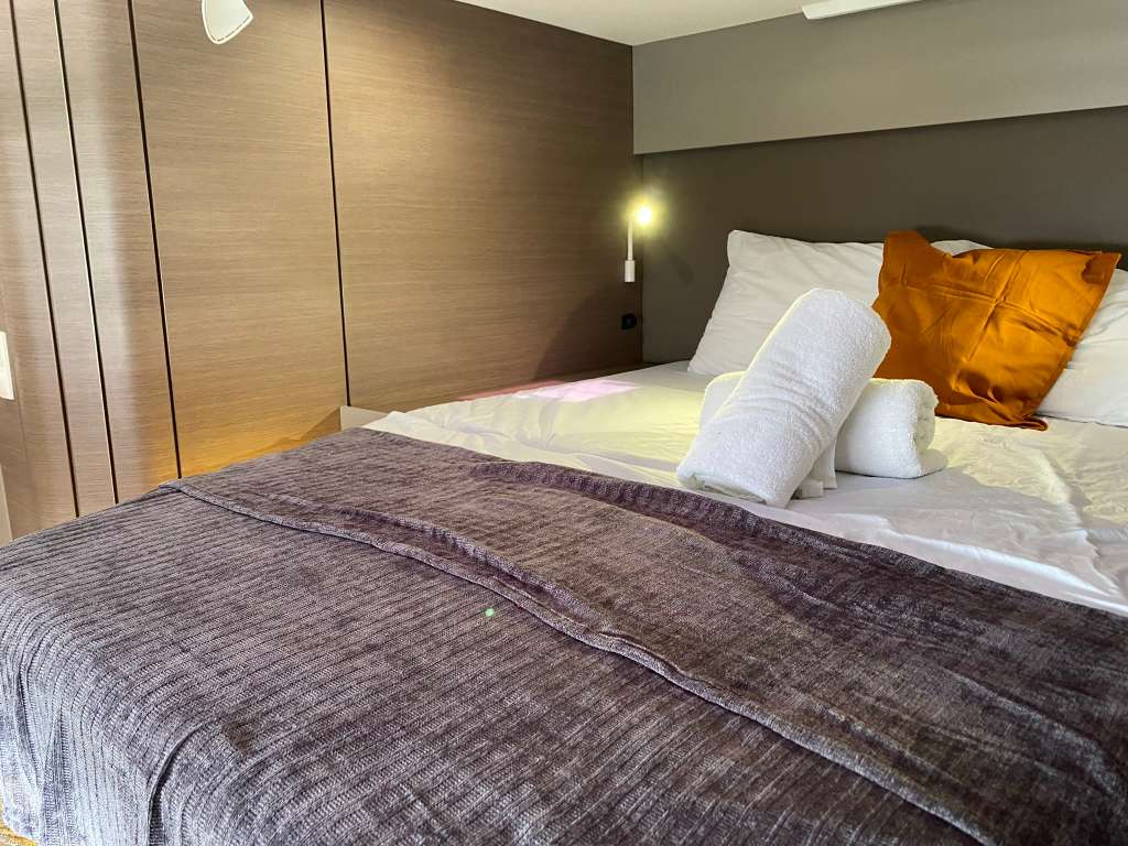 Bali Catspace master cabin bedroom with king bed, closet, and warm lighting