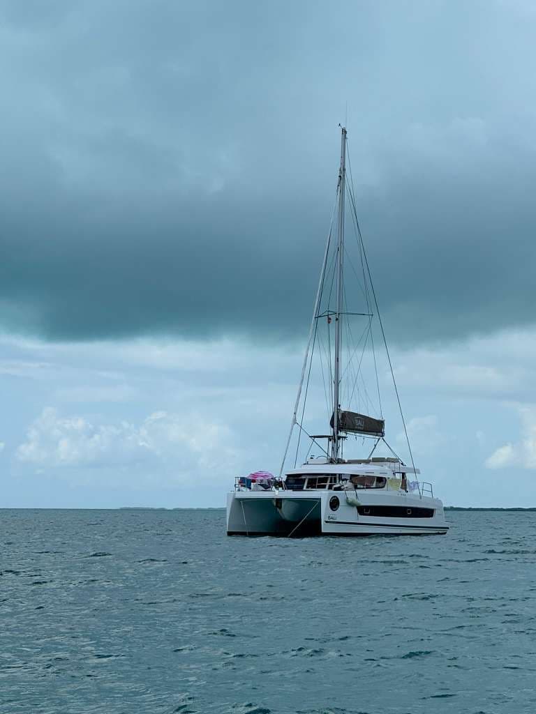 Bali Catspace catamaran at anchor under moody overcast sky
