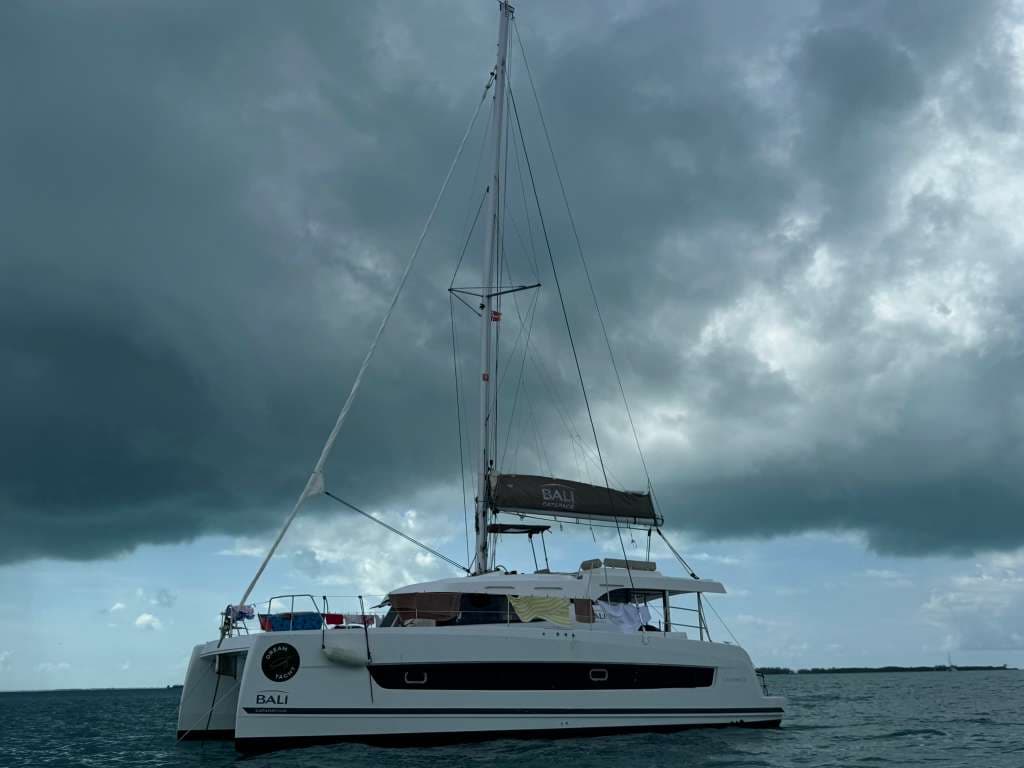 Bali Catspace catamaran at anchor with dramatic dark clouds