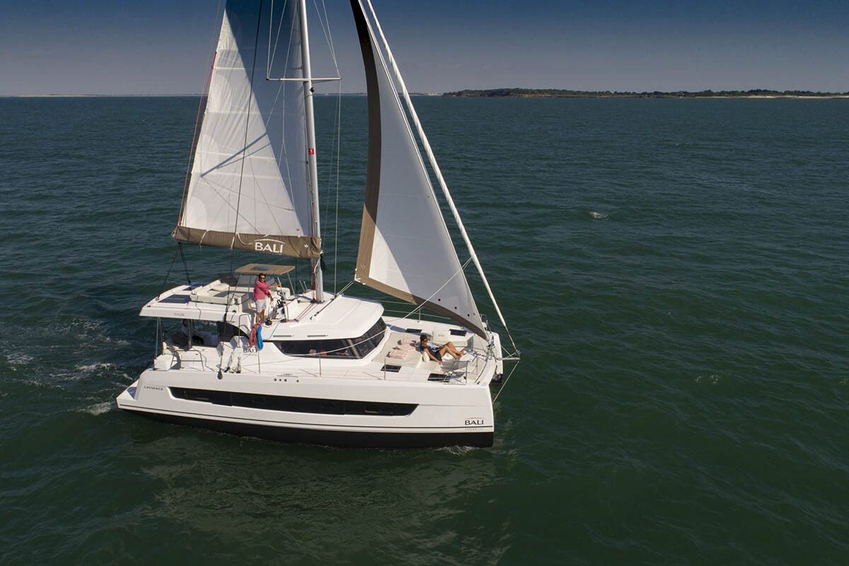 Bali Catspace catamaran sailing with full sails up, aerial perspective