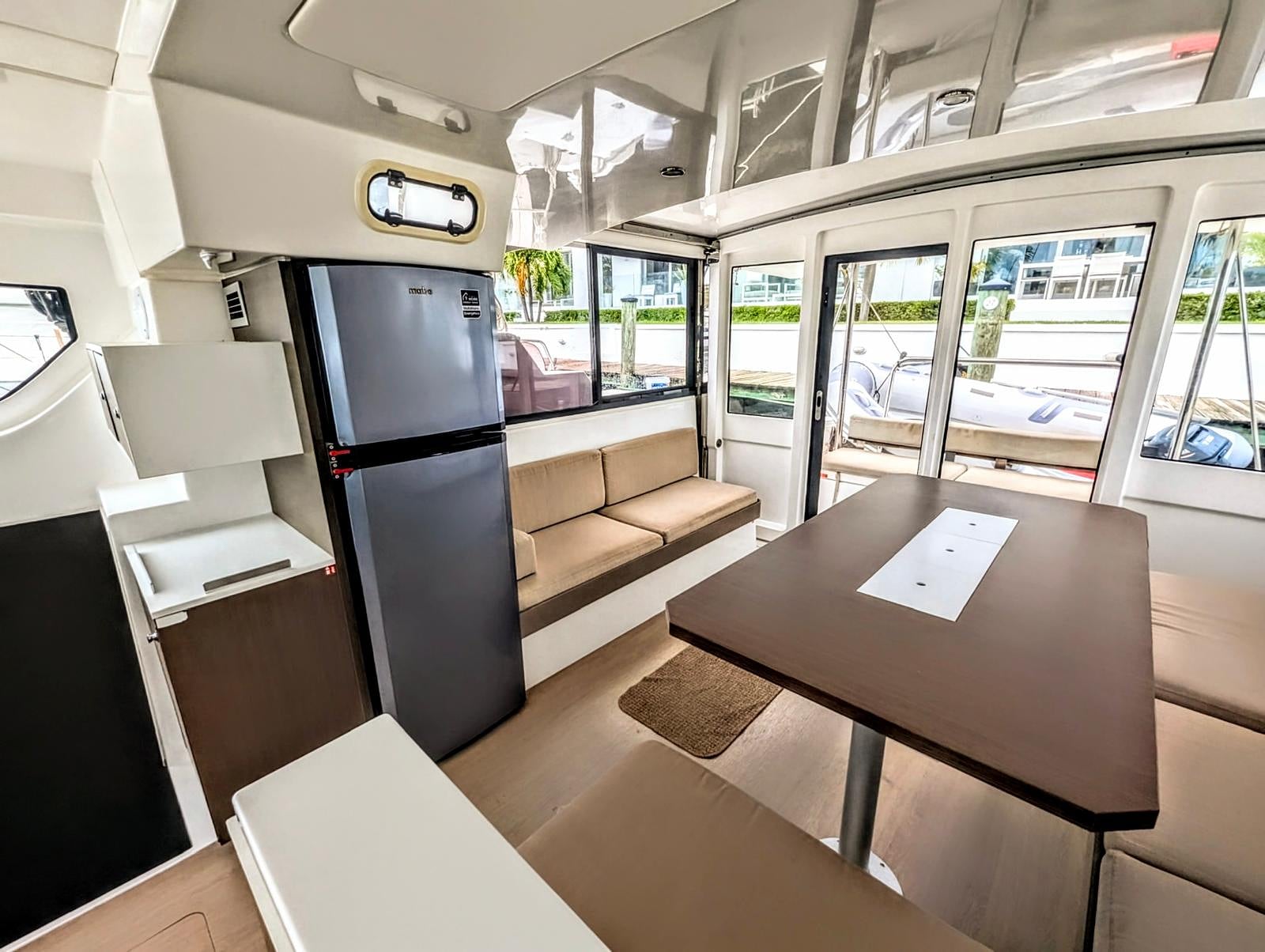 Galley interior with stainless fridge and marina visible through window