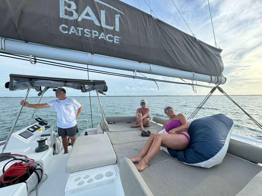 Captain and guests on the foredeck at sunset aboard Let's Geaux